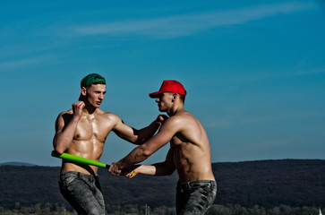 macho men fighting with baseball bat on blue sky