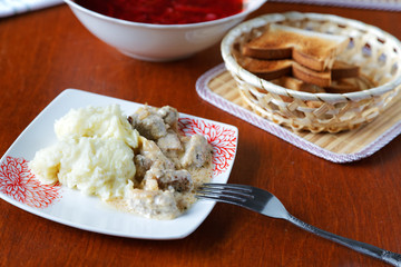 plate of potatoes with meat and croutons on the kitchen table