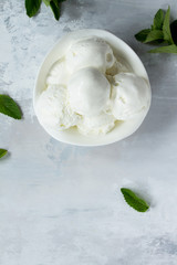 Balls of cream ice cream in a cup on a marble kitchen table. Top view with copy space.