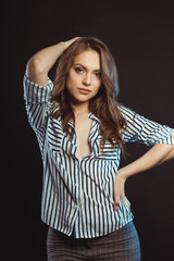 Pretty young model posing in striped shirt at studio