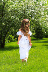 Obraz premium Girl in white dress on background of green Park. Pid from behind.