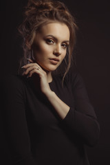 Dramatic portrait of young brunette model in the shadows