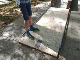 Ein anonymes Kind steht mit Beinen auf einer Minigolfbahn