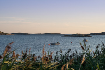 The little rowboat, bumps on the bay in the evening breeze from the outer islands and with the sun...
