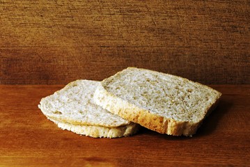 Two slices of toast, made from whole meal, on a wooden plate