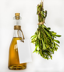 The homemade golden brown spiced sweet gale shades, shine in the clear glass bottle and a lot of fresch aromatic gray-green sweet-gale hanging outside