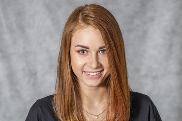 Fototapeta premium Girl at the age of nineteen poses on a light background for advertising