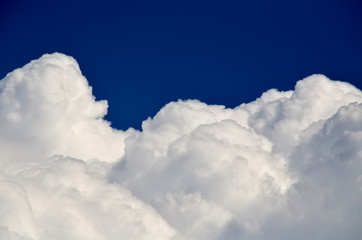 Blue sky with white and gray cumulus clouds. Closeup