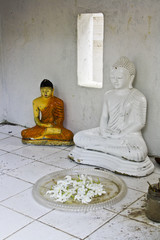 Alte Buddha-Statuen mit Opfergaben in einem asiatischen Tempel