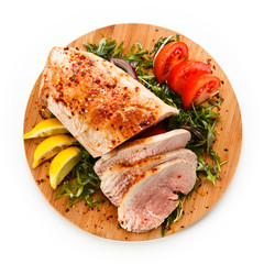 Roast ham with vegetables on wooden desk 