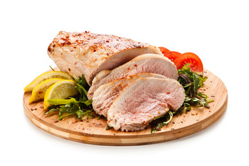 Roast ham with vegetables on wooden desk 