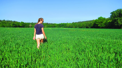 Young Caucasian White Woman in Barley Farm Field on a Sunny Blue Sky Day, England, UK