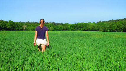 Young Caucasian White Woman in Barley Farm Field on a Sunny Blue Sky Day, England, UK