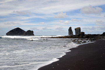 the village "mosteiros" on the island of azores with its black beaches, the breaking waves of the atlantic and the rock " ilh&eacute;us dos mosteiros;