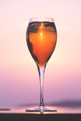 Aperol spritz at a wooden pier at sunset. Luxury resort vacation concept. Festive relax getaway background.