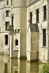 Fototapeta na wymiar La muraille en pierres calcaires percés de fenêtres du château-fort de Bouchout au Jardin Botanique National de la Belgique à Meise