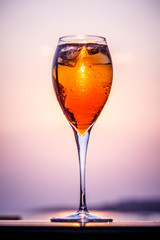 Aperol spritz at a wooden pier at sunset. Luxury resort vacation concept. Festive relax getaway background.