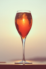 Aperol spritz at a wooden pier at sunset. Luxury resort vacation concept. Festive relax getaway background.