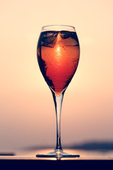 Aperol spritz at a wooden pier at sunset. Luxury resort vacation concept. Festive relax getaway background.