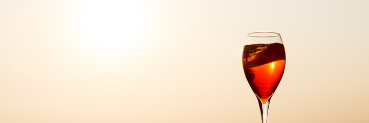 Aperol spritz at a wooden pier at sunset. Luxury resort vacation concept. Festive relax getaway...