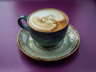 a cup of coffee on a purple table