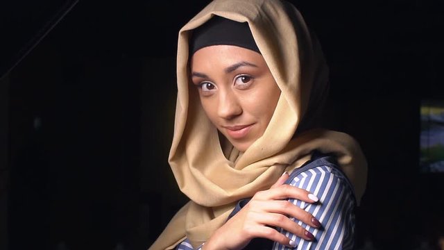 Portrait of attractive girls in traditional Muslim clothes. The girl in hijab looks at the camera and smiling. slow motion