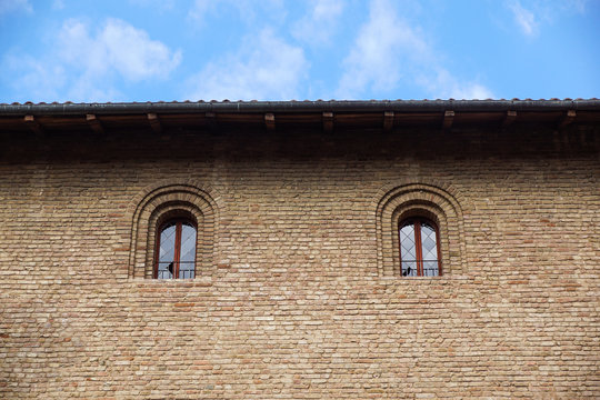 Castle window in a medieval style. Double arched window on a facade of medieval wall. Biforium - ancient window with column, old architecture element of Roman and Gothic styles.