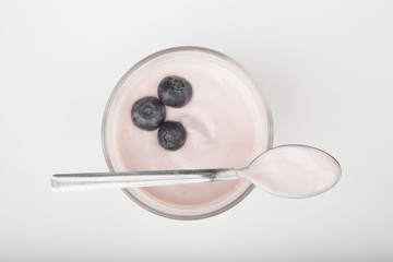 glass of fresh berries and yogurt isolated on white background