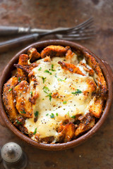 Spiced potato wedges fries with mozzarella and parsley 