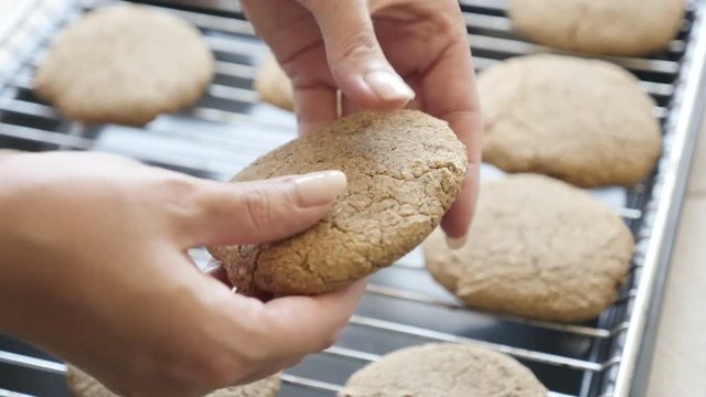 Picking bread product from baking rack and halving slow motion 1080p FullHD footage - Close-up breaking homemade cookie on two pieces slow-mo 1920X1080 HD video
