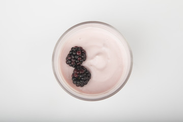 glass of fresh berries and yogurt isolated on white background