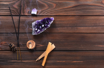 Composition of esoteric objects used for healing, meditation, relaxation and purifying. Amethyst stones, palo santo wood, Aromatic sticks on dark background. .