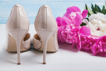 High heel shoes and bouquet of peonies