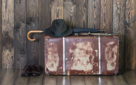 Umbrella, old suitcase, vintage shoes and hat, old wooden wall