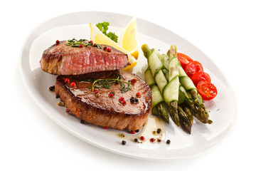 Grilled beefsteak with asparagus on white background 