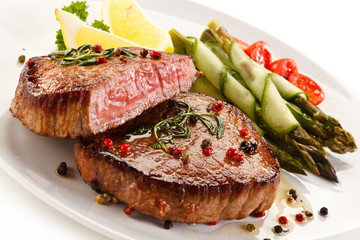 Grilled beefsteak with asparagus on white background 
