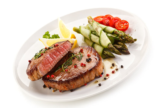 Grilled beefsteak with asparagus on white background 