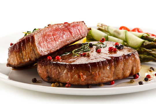 Grilled beefsteak with asparagus on white background 