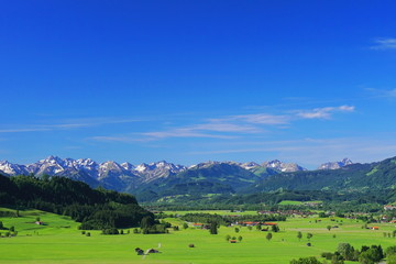 Fototapeta na wymiar Landschaft mit Dorf und Häuser in den Alpen, Bayern