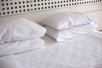 Fototapeta na wymiar Pillows on bed in hotel room