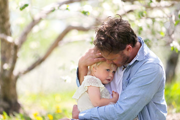 Father Holding and Comforting Sad Baby Daughter