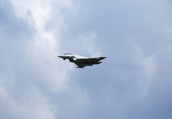 Modern jet fighter flying high in the sky. 