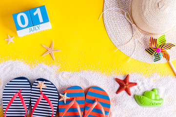 July 1st. Image of july 1 calendar with summer beach accessories and traveler outfit on background. Summer vacation concept