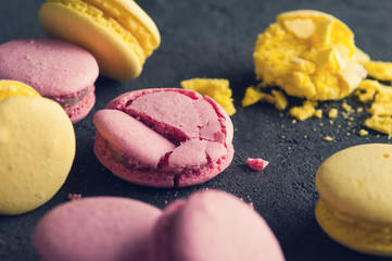 Closeup of pink macaroons on black concrete background
