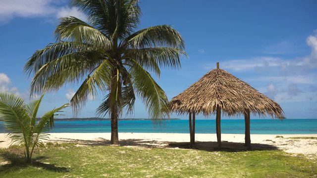 Beach with white sand with beach house on a tropical island Daco. Beautiful sky, sea, resort. Seascape: Ocean and beautiful beach paradise. Philippines. 4K video. Travel concept.