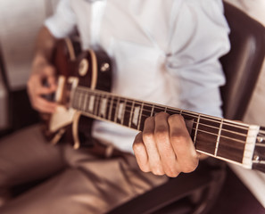 Handsome businessman playing guitar