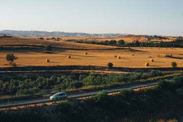 Fototapeta na wymiar Golden sunset over farm field with hay bales