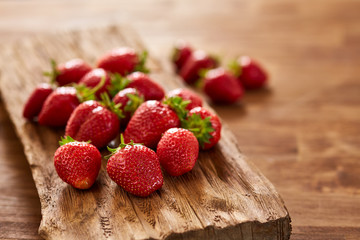 Fresh red strawberries on a wooden board on a wooden table.