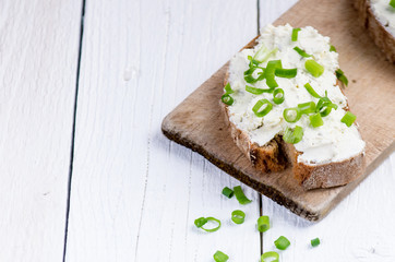 Bread with butter and spread. Concept of healthy breakfast. Spring onion, Vegetables. Wooden white...