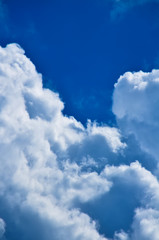 Blue sky with white and gray cumulus clouds. Closeup